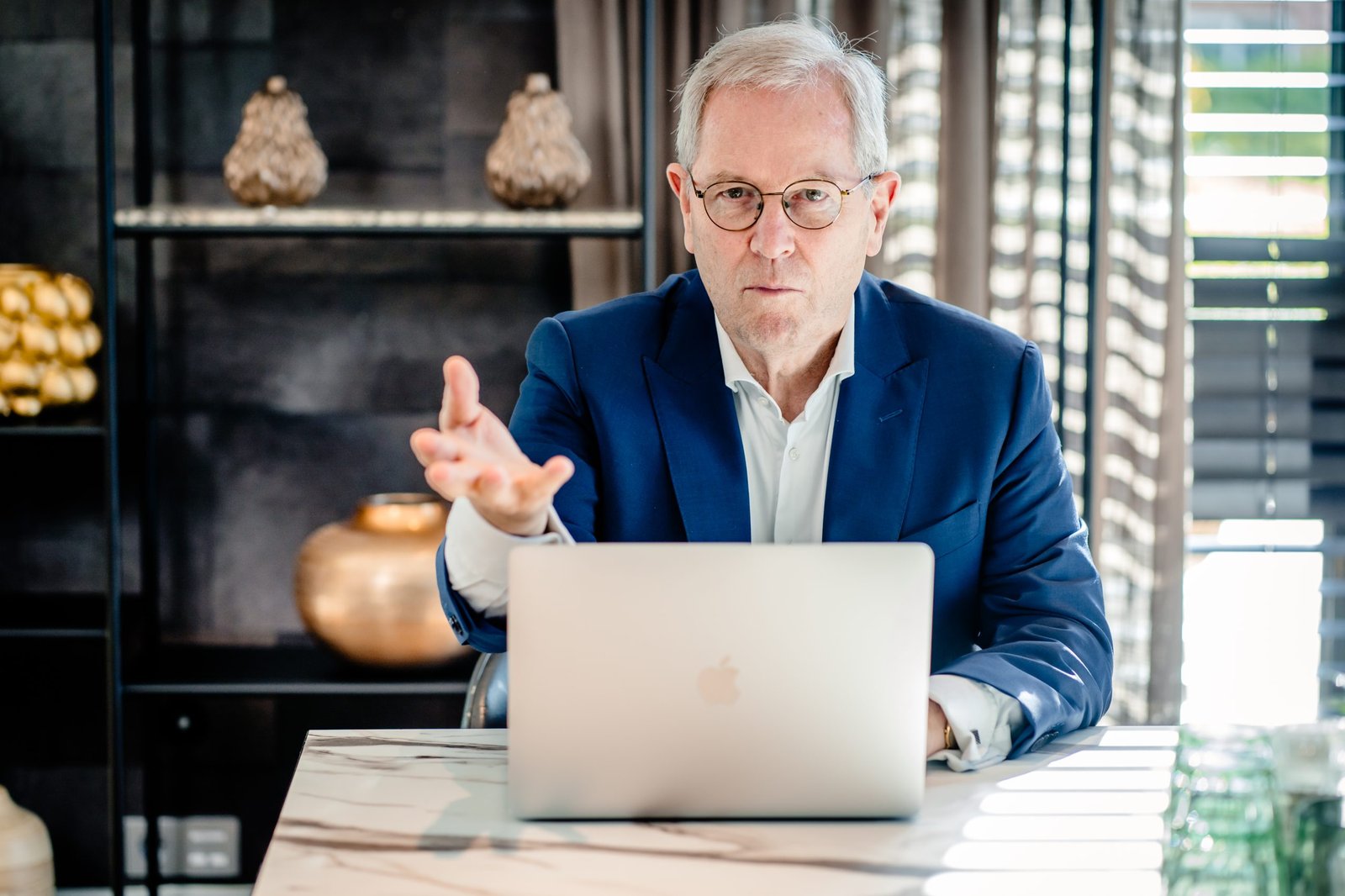 Robert Oosthout geeft uitleg aan een tafel met een laptop.